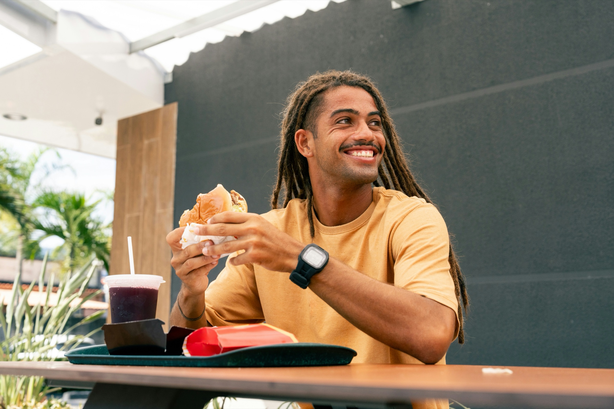 A guest smiling over his meal outside a restaurant